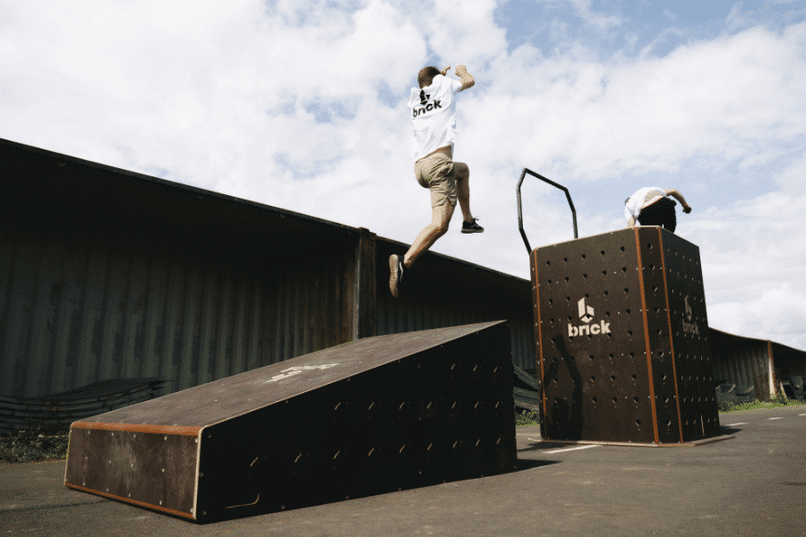 photo d'un jeune homme franchissant un mur incliné pour atteindre le donjon de la marque brick photo par matthieu metivet